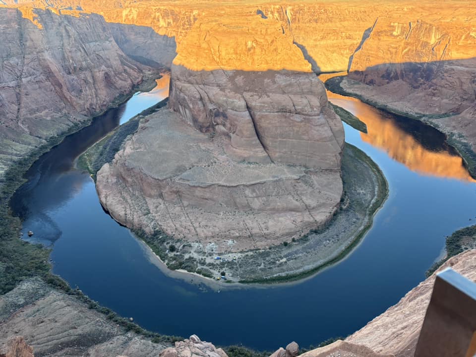 Daytime canyon view at Horseshoe Bend Arizona with blue water and red sandstone cliffs